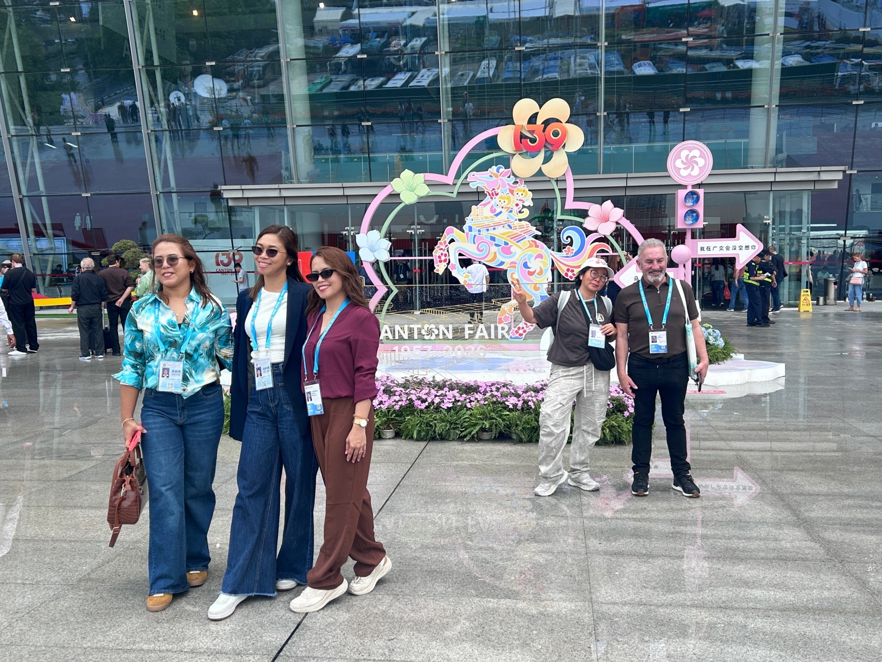 第139届广交会现场，海外采购商与富有中国元素的“策马奔腾”打卡装置合影。实习生 兰航宇摄